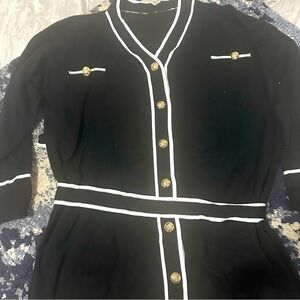 Black and sweater with gold buttons and tie around waist